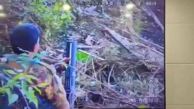 Chinese border guards watching a Myanmar Junta soldier's weapons malfunction through CCTV