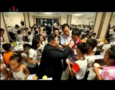 Slender North Korean kids gives food to Kim