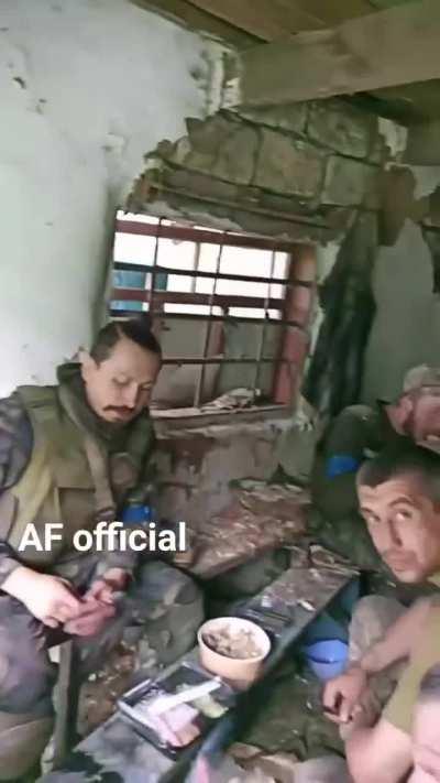 Ukrainian infantry take a break in an abandoned village.