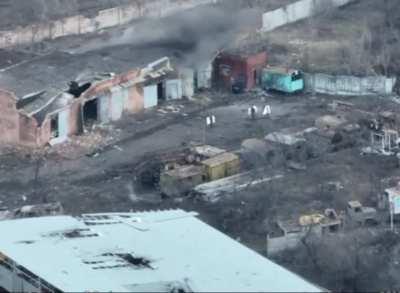 Russian soldiers carrying white bags are hit directly by artillery