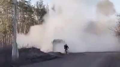 Cyclist casually rides past the active Himars