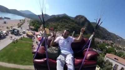 A Turkish daredevil paragliding on his couch lands safely.