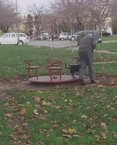 Grandpa giving his good boy a ride on the Merry-go-round in a Playground