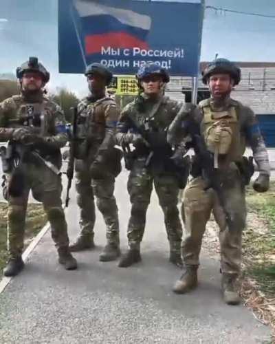 Ukrainian soldiers reply to Russia in front of billboard 