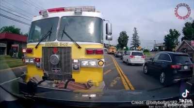 An idiot driver yells at the firetruck with sirens on and doesn't back out