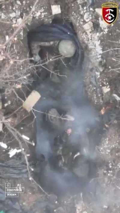 A Ukrainian drone dropping a grenade on two Russian soldiers