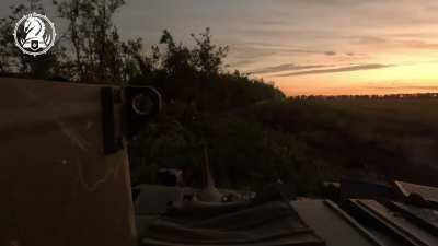 Two Ukrainian Bradleys suppress a treeline and drop off assault troops to take the position from the invaders.