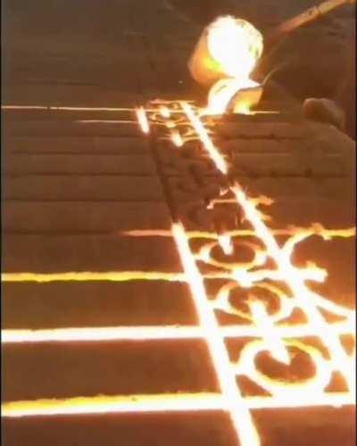 Molten iron poured into a sand mold