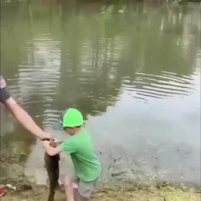 Little kid bringing in a huge fish