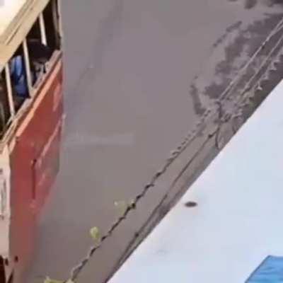 Woman helps blind man board the bus in Kerala, India.