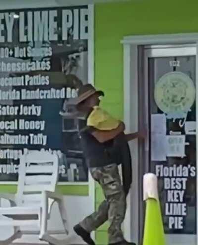 Florida man casually bringing his pet, shirt-wearing alligator back into his shop