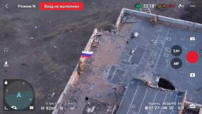 Russian troops raise their flag over a ruined building in Vuhledar - October 2024