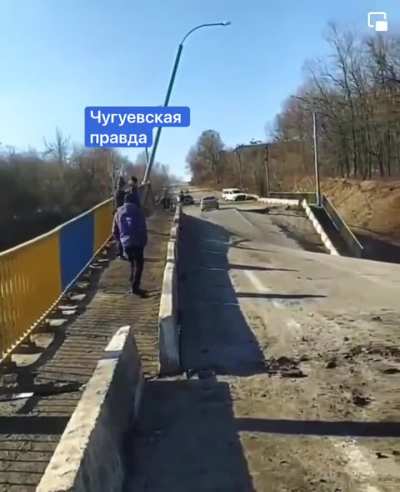 Some madman in a car at speed crosses a destroyed bridge in Ukraine