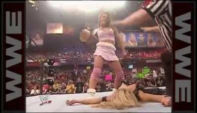 Mickie standing over Trish