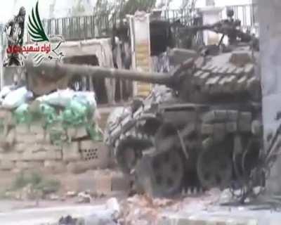 Opposition fighters observe a battered Syrian Army T-72 for a minute before engaging with an RPG - 2013