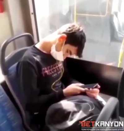 The boy who fell asleep on the bus is gently woken up by the bus driver