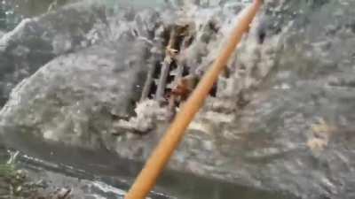 This guy voluntarily drained flooded street with his garden rake