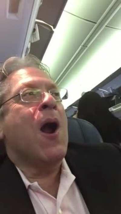 Man laughs after Passenger screams at screaming kid on plane