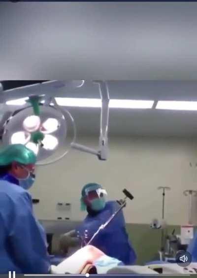 Orthopaedic surgeon removing nail from femur