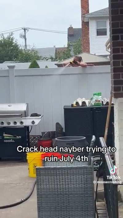 Neighbor soaks grill with hose from over the fence during 4th of July BBQ