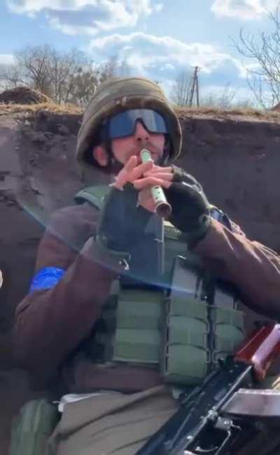 A Ukrainian military man plays the sopilka in the trenches