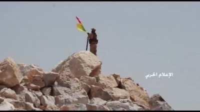 Hezbollah fighter replaces ⁦‪al-Nusra flag with ⁦‪Hezbollah‬⁩ and ⁦‪Lebanon’s flag‬⁩ in ⁦‪Arsal‬⁩ after defeating the terrorist group (2017-07-23)