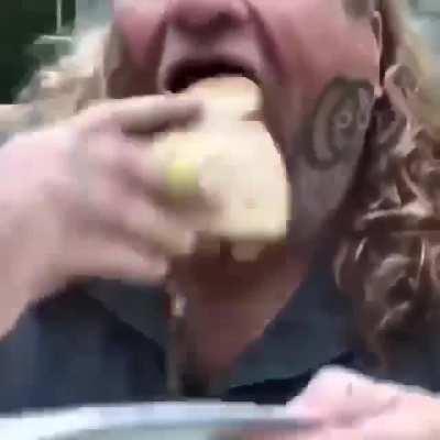 Man eating a worm sandwich with mustard