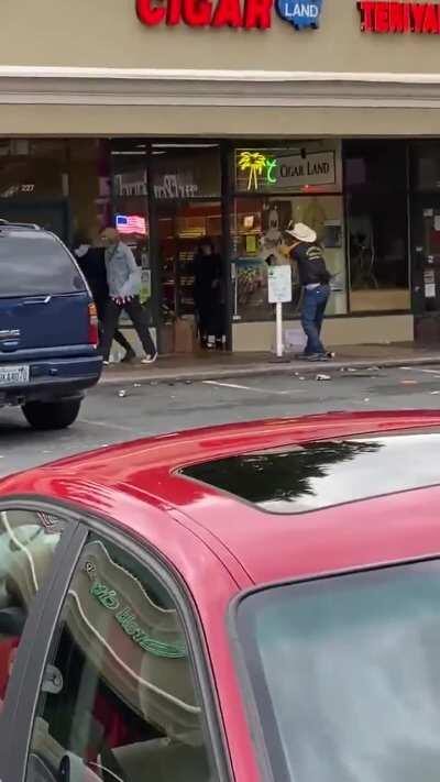 Cigar shop owner defends store, forcing looters out with his handgun.