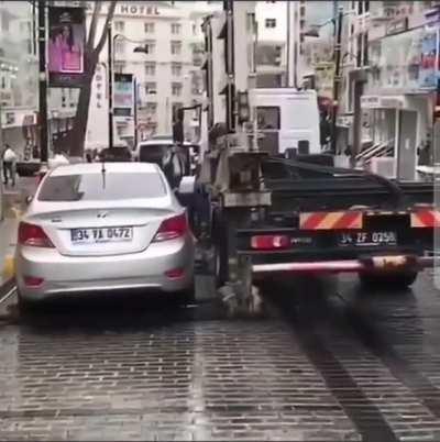 Tow Truck lifting a car that is parked illegally in Europe