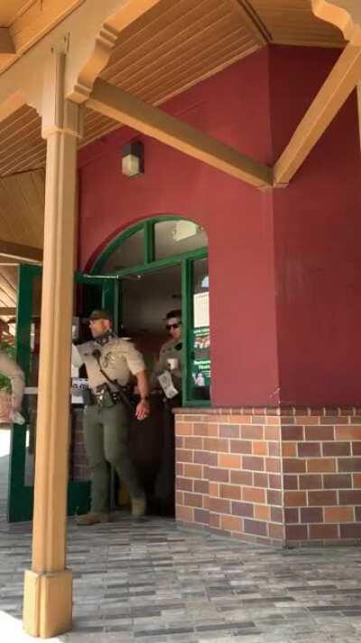 0:35 [7/1/2020] Riverside County Sheriffs walking out of a restaurant all without masks on in CA