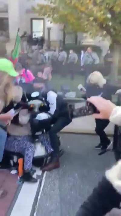 Police pepper spray people, including children, marching to the polls in Alamance County, North Carolina. Several of the children vomited; a woman is seen falling out of a wheelchair. Many of the the voters were ultimately turned away from the polls.