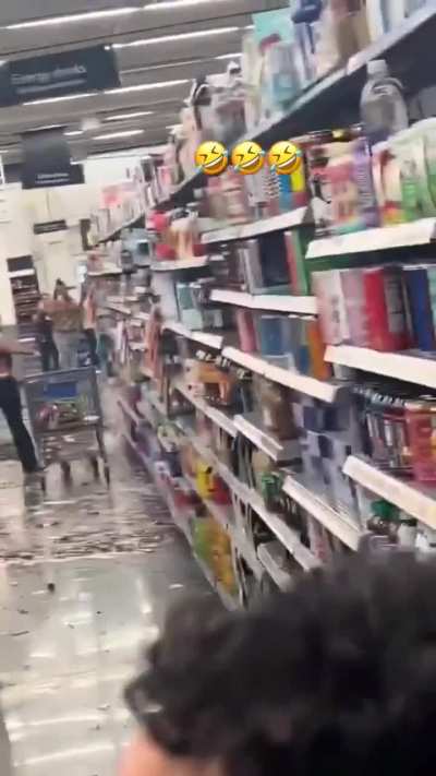 Drunk woman breaks a bunch of liquor bottles in a store