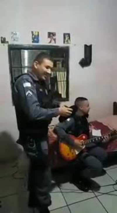 Policeman playing metallica on person's guitar before arresting hime.