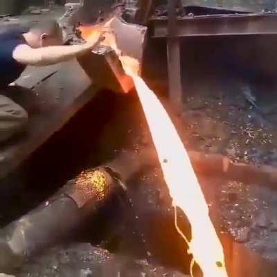 Leidenfrost effect in action as man slaps molten lava with bare hands.