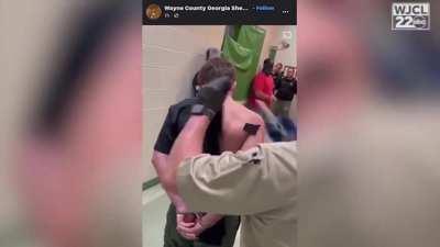 Dayton Beasley Georgia deputy has his official uniform cut off as he is booked into jail.