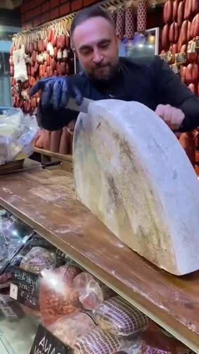 Cutting a wheel of cheese