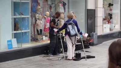 Woman in Liverpool tries to stop a busker earning a crust.