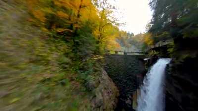 Flying under a bridge into a gorge