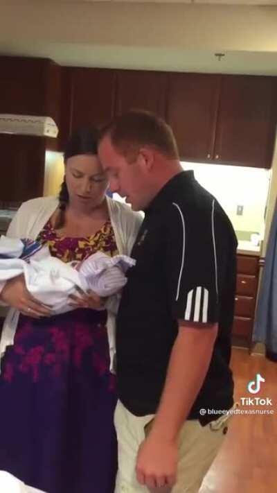 Mother hands her newborn baby to the adopting couple