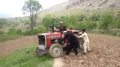 Pushing a tractor to start it on a mountainous terrain