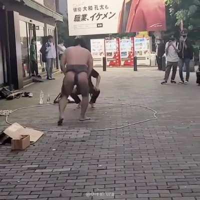 Sumo wrestling in the streets of Shinjuku, Tokyo, 2022. Osumosan against what it looks like an average passerby...