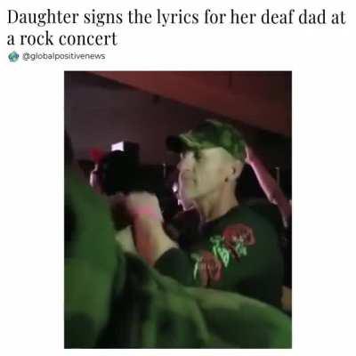 Girl signs the lyrics for her dad at a music concert