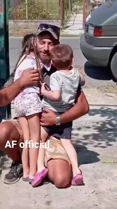 A Ukrainian father, back from the front on leave, hugs his kids again.