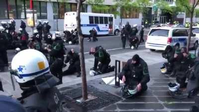 Montrealers think the police gets one one knee as sign of compassion only to realize they are putting on gas mask as shooting is about to start