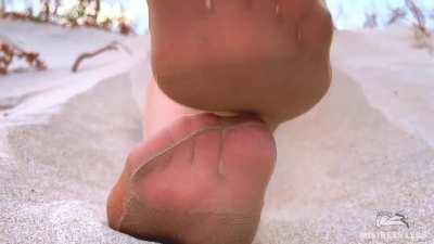 My sandy nylon feet teasing you on a beach at sunset