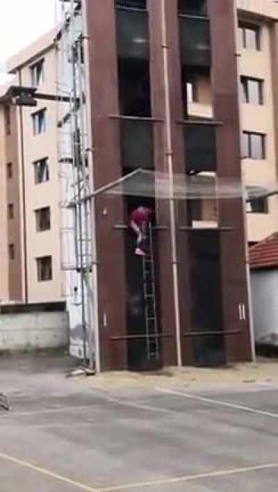 This fireman practising climbing building with a ladder as quickly as possible