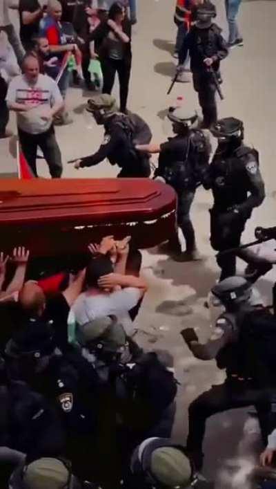 Israeli forces beating mourners carrying casket of murdered journalist Sherine Abu Aqleh.