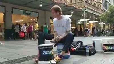 Street artist drumming on a single bucket