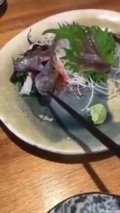 Fish served at restaurant bites chopstick.