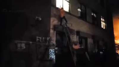 Rioters on ladders smashing building windows